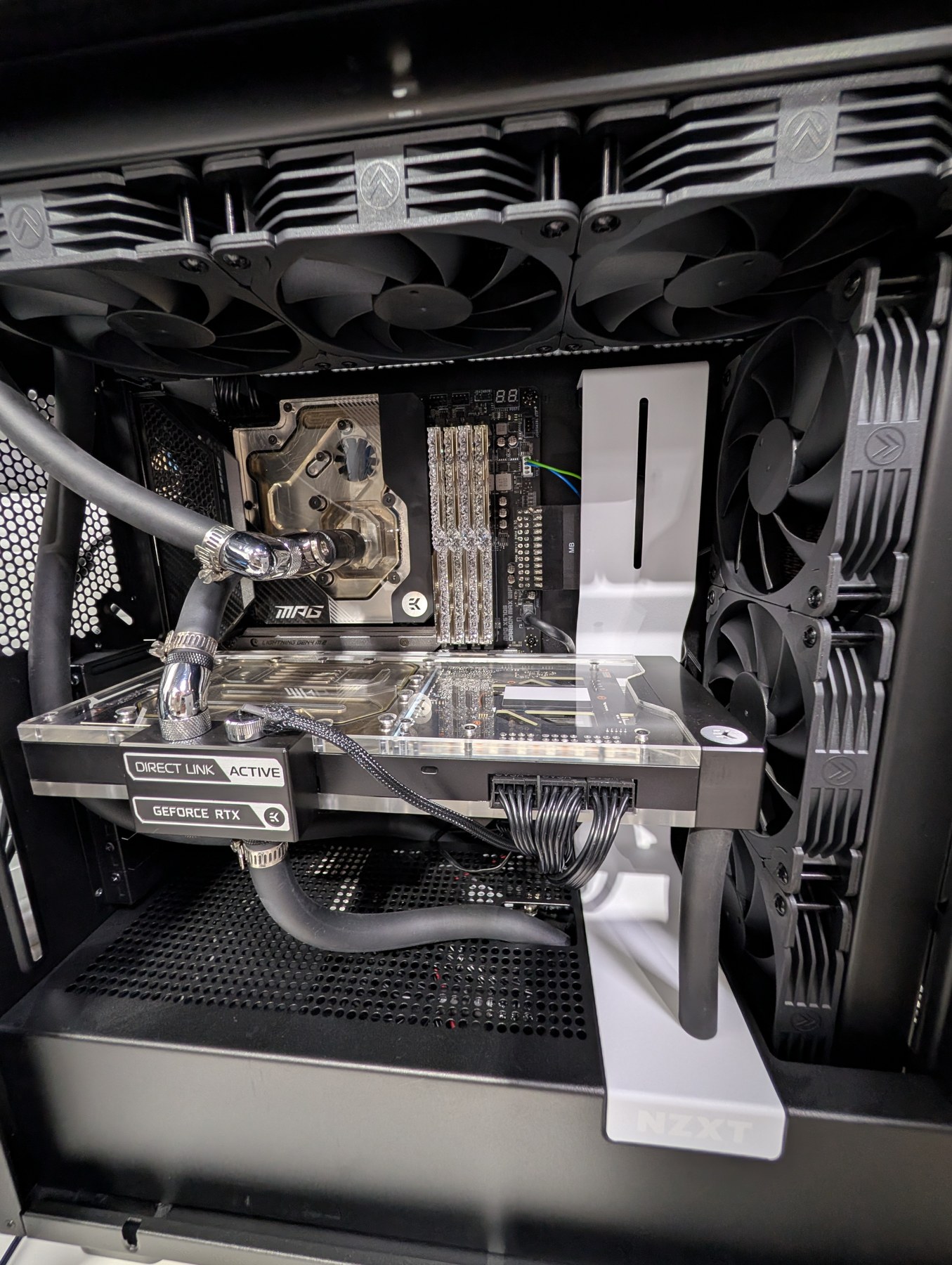 Close-up of the liquid-cooling loop, GPU water block, radiator fans, and workstation components